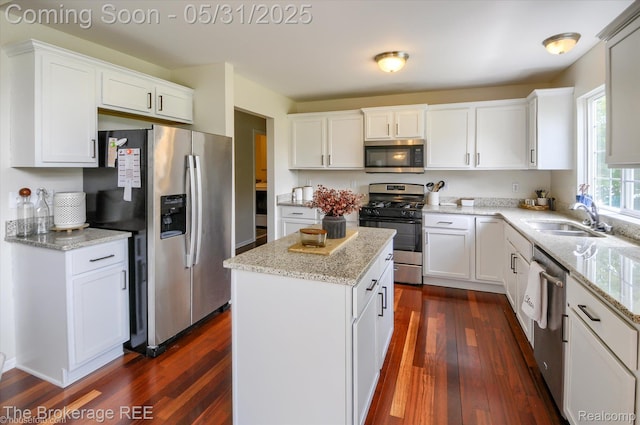 4422 Jordan Dr, Grand Blanc, MI 48439 - kitchen with appliances with stainless steel finishes, a sink, dark wood-style floors, a center island, and white cabinetry