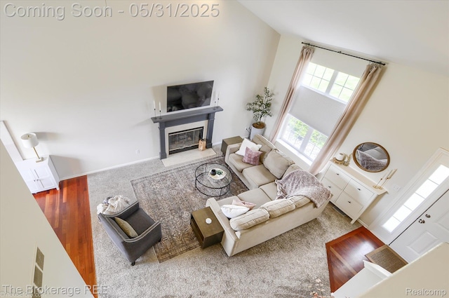 4422 Jordan Dr, Grand Blanc, MI 48439 - living area featuring a fireplace with flush hearth, carpet, and a towering ceiling