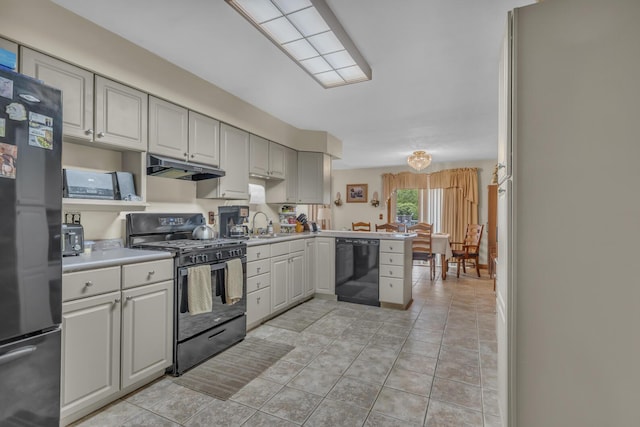 3460 Sears Rd, Horton, MI 49246 - kitchen with black appliances, under cabinet range hood, light tile patterned flooring, light countertops, and a peninsula