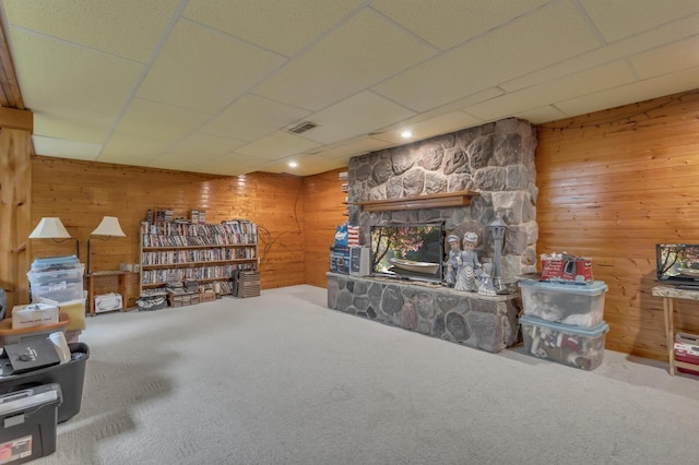 3460 Sears Rd, Horton, MI 49246 - living room with carpet, wood walls, a fireplace, and a drop ceiling