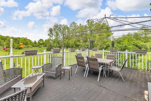 3460 Sears Rd, Horton, MI 49246 - deck with outdoor dining space, a yard, and view of scattered trees