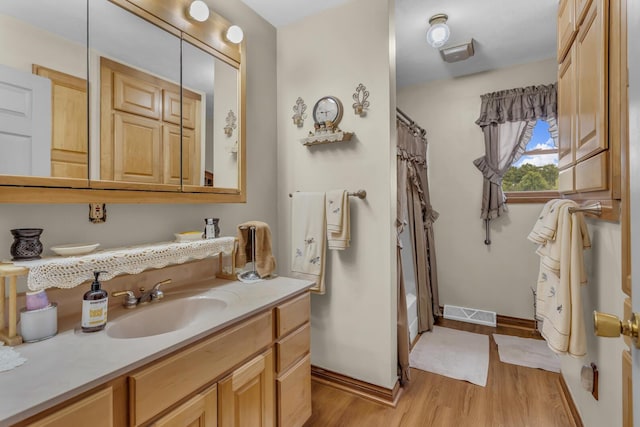 3460 Sears Rd, Horton, MI 49246 - bathroom featuring wood finished floors, baseboards, vanity, and shower / tub combo with curtain
