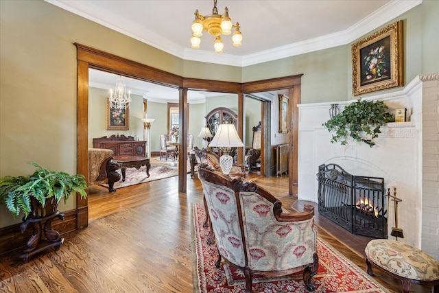 303 S State Ave, Alpena, MI 49707 - dining area with a chandelier, crown molding, wood finished floors, a warm lit fireplace, and ornate columns
