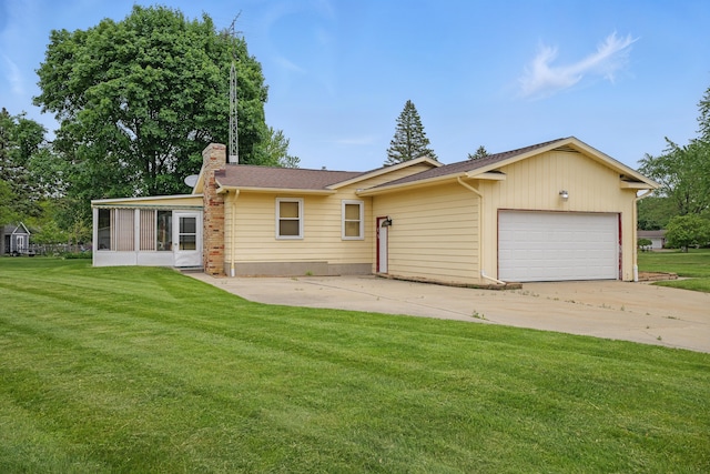 1451 Peachwood Dr, Flint, MI 48507 - back of house with a chimney, a garage, a sunroom, and a yard