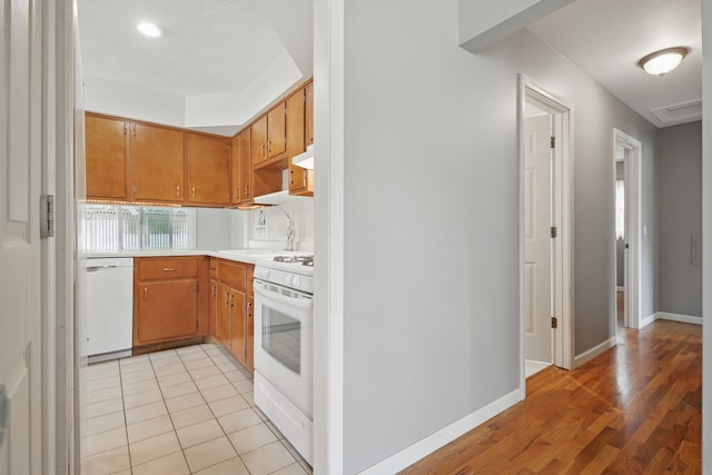 1451 Peachwood Dr, Flint, MI 48507 - kitchen with white appliances, a sink, light countertops, under cabinet range hood, and light wood-type flooring