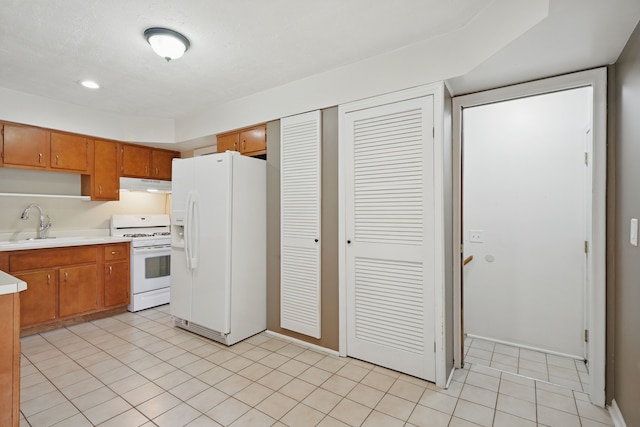 1451 Peachwood Dr, Flint, MI 48507 - kitchen with white appliances, under cabinet range hood, light countertops, brown cabinets, and recessed lighting