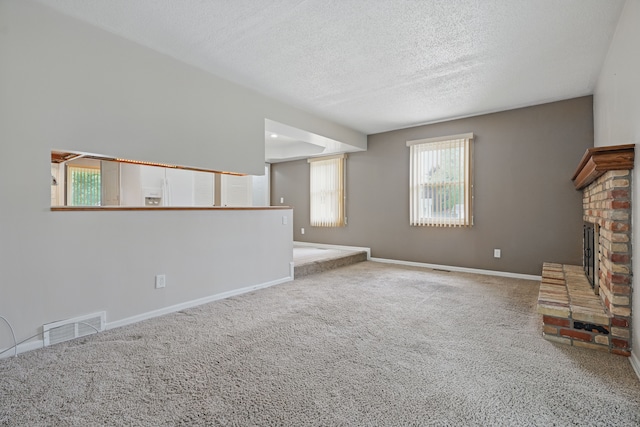 1451 Peachwood Dr, Flint, MI 48507 - unfurnished living room featuring carpet floors, a fireplace, a textured ceiling, and baseboards