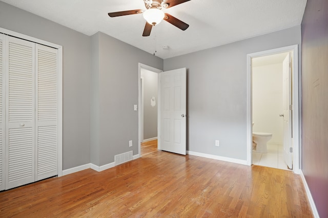 1451 Peachwood Dr, Flint, MI 48507 - unfurnished bedroom featuring a closet, light wood-style floors, baseboards, connected bathroom, and a ceiling fan