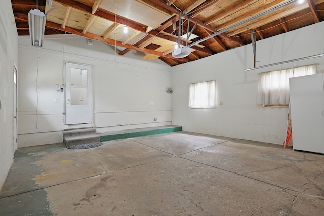 1451 Peachwood Dr, Flint, MI 48507 - garage with a garage door opener and freestanding refrigerator
