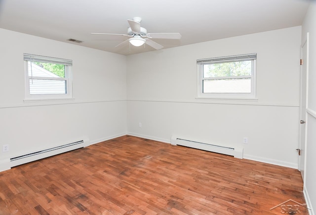 1466 Wilson Ave, Saginaw, MI 48638 - unfurnished room featuring a baseboard heating unit, wood finished floors, ceiling fan, and baseboards