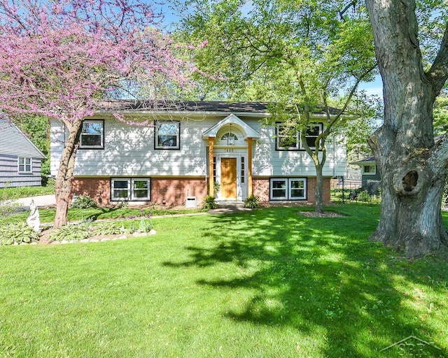 1466 Wilson Ave, Saginaw, MI 48638 - bi-level home featuring a front lawn and brick siding