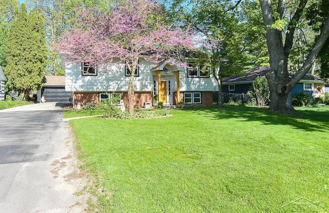 1466 Wilson Ave, Saginaw, MI 48638 - raised ranch with a front lawn, brick siding, and a detached garage