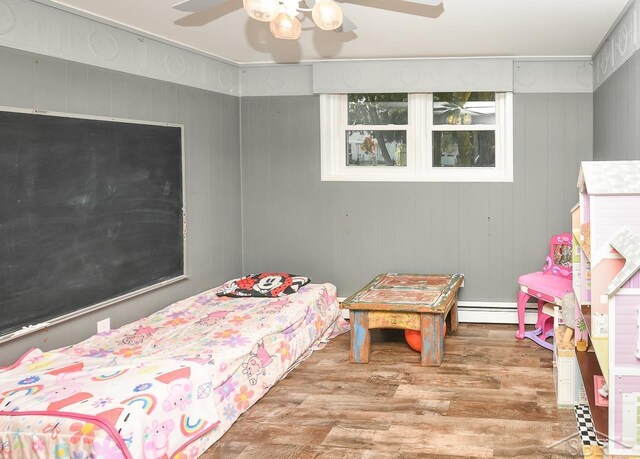 1466 Wilson Ave, Saginaw, MI 48638 - bedroom with wood finished floors, a baseboard heating unit, and ceiling fan