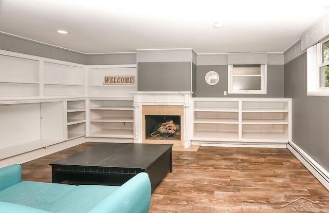 1466 Wilson Ave, Saginaw, MI 48638 - living room with a baseboard radiator, a fireplace with flush hearth, wood finished floors, and recessed lighting