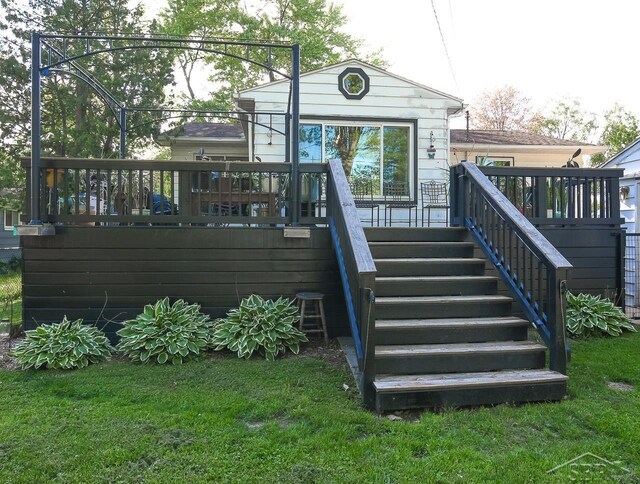 1466 Wilson Ave, Saginaw, MI 48638 - back of house with stairway, a lawn, and a wooden deck