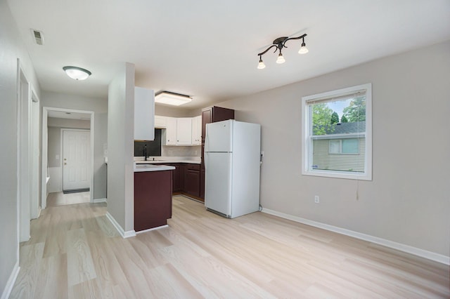 604 W Hill St, Plainwell, MI 49080 - kitchen with freestanding refrigerator, a sink, light wood-style flooring, light countertops, and baseboards