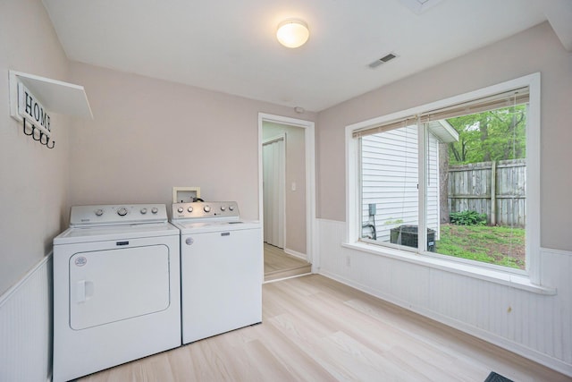 604 W Hill St, Plainwell, MI 49080 - laundry room with washer and dryer, a wainscoted wall, and light wood-style floors