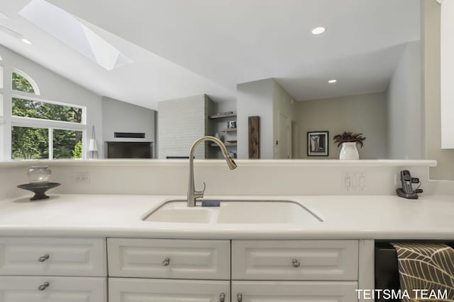 12993 144th Ave, Grand Haven, MI 49417 - kitchen with a sink, a skylight, white cabinetry, light countertops, and recessed lighting