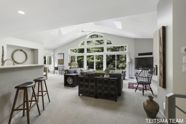 12993 144th Ave, Grand Haven, MI 49417 - carpeted living room featuring a skylight, high vaulted ceiling, and a ceiling fan