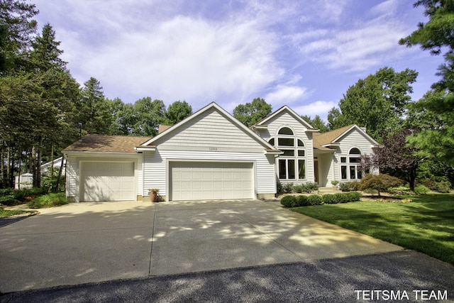 12993 144th Ave, Grand Haven, MI 49417 - view of front of house featuring a garage, concrete driveway, a front lawn, and a chimney