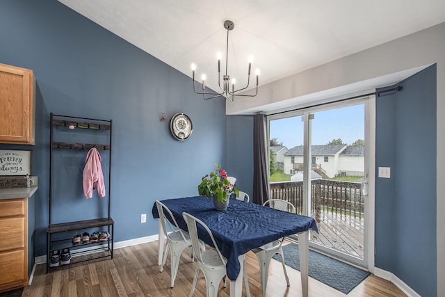3076 Daybreak Ln, Holland, MI 49424 - dining area with a chandelier, dark wood-style flooring, baseboards, and vaulted ceiling