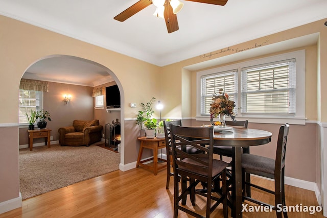 429 Van Allen St SE, Wyoming, MI 49548 - dining area with arched walkways, a ceiling fan, light wood finished floors, baseboards, and ornamental molding