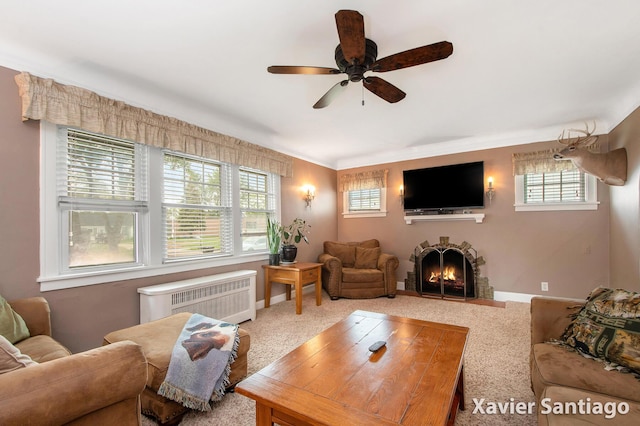429 Van Allen St SE, Wyoming, MI 49548 - living room featuring radiator heating unit, ceiling fan, a warm lit fireplace, carpet flooring, and crown molding