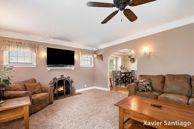 429 Van Allen St SE, Wyoming, MI 49548 - carpeted living room featuring arched walkways, ceiling fan, ornamental molding, a fireplace with flush hearth, and baseboards