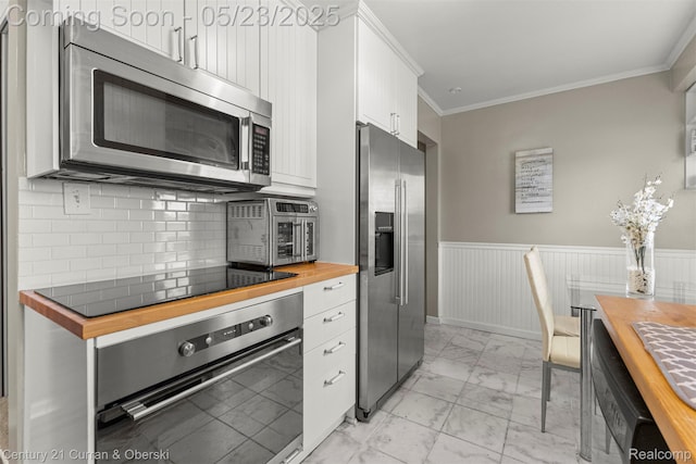 3346 Westpoint St, Dearborn, MI 48124 - kitchen featuring butcher block countertops, appliances with stainless steel finishes, light marble finish flooring, white cabinetry, and ornamental molding
