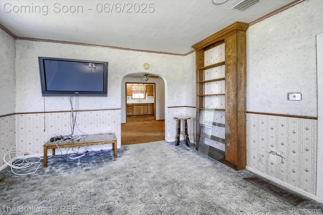 8114 Wilson Rd, Otisville, MI 48463 - carpeted living room featuring wallpapered walls, arched walkways, crown molding, a sink, and baseboards
