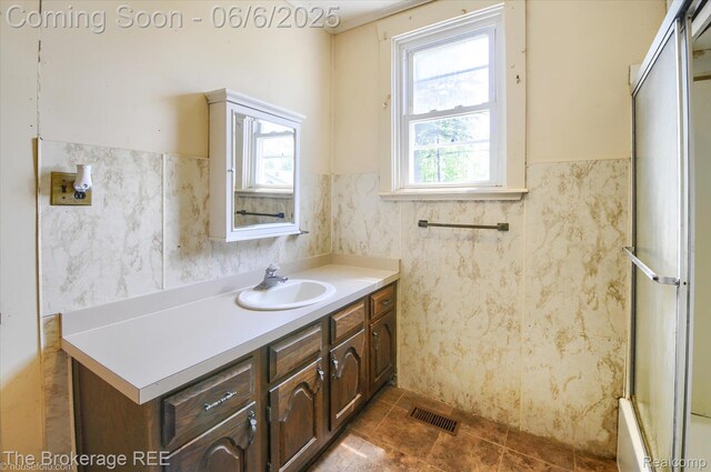 8114 Wilson Rd, Otisville, MI 48463 - bathroom featuring vanity, a wainscoted wall, and tile walls
