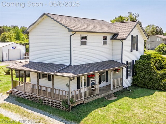 8114 Wilson Rd, Otisville, MI 48463 - farmhouse-style home featuring covered porch, a front yard, an outbuilding, a shingled roof, and a garage