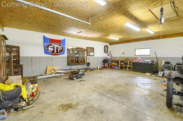 8114 Wilson Rd, Otisville, MI 48463 - garage featuring a wainscoted wall and wooden walls
