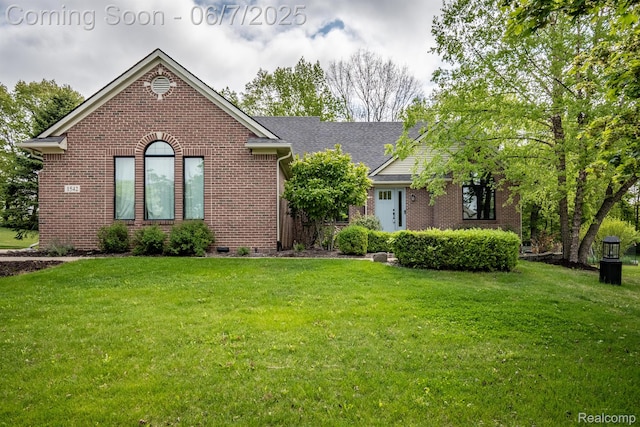 1542 Summerfield Ln, Howell, MI 48843 - view of front of home with brick siding, a front lawn, and roof with shingles