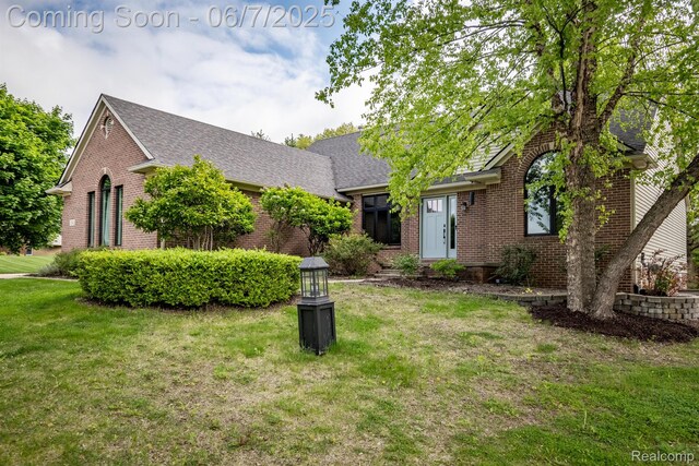 1542 Summerfield Ln, Howell, MI 48843 - view of front of property featuring brick siding, a front yard, and roof with shingles
