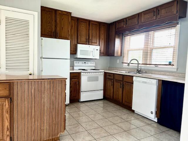 526 18th St, Jackson, MI 49203 - kitchen with white appliances, light countertops, and light tile patterned floors