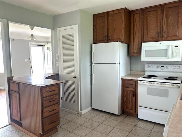 526 18th St, Jackson, MI 49203 - kitchen with white appliances, light tile patterned floors, light countertops, and brown cabinets