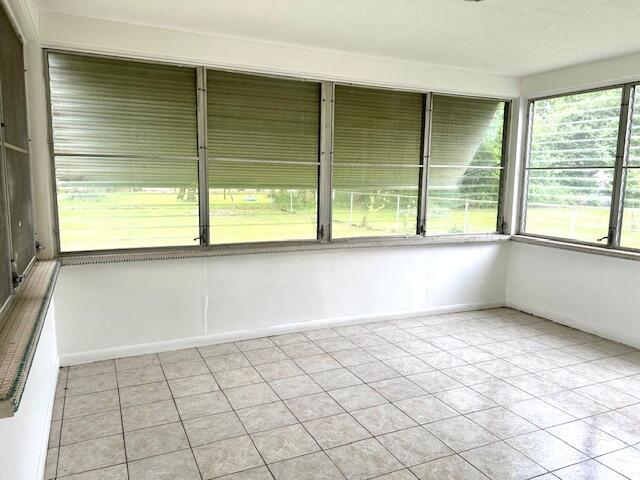 526 18th St, Jackson, MI 49203 - unfurnished sunroom with tile patterned floors