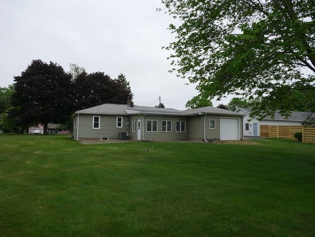 12589 Perry Rd, Battle Creek, MI 49015 - rear view of house with a lawn, an attached garage, and central AC