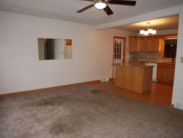 12589 Perry Rd, Battle Creek, MI 49015 - kitchen with white dishwasher, carpet, a ceiling fan, a center island, and baseboards