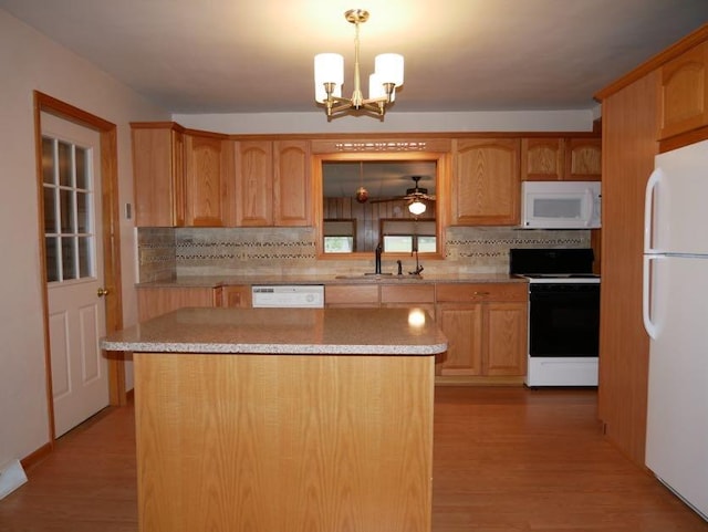 12589 Perry Rd, Battle Creek, MI 49015 - kitchen with white appliances, a sink, decorative backsplash, a chandelier, and light countertops