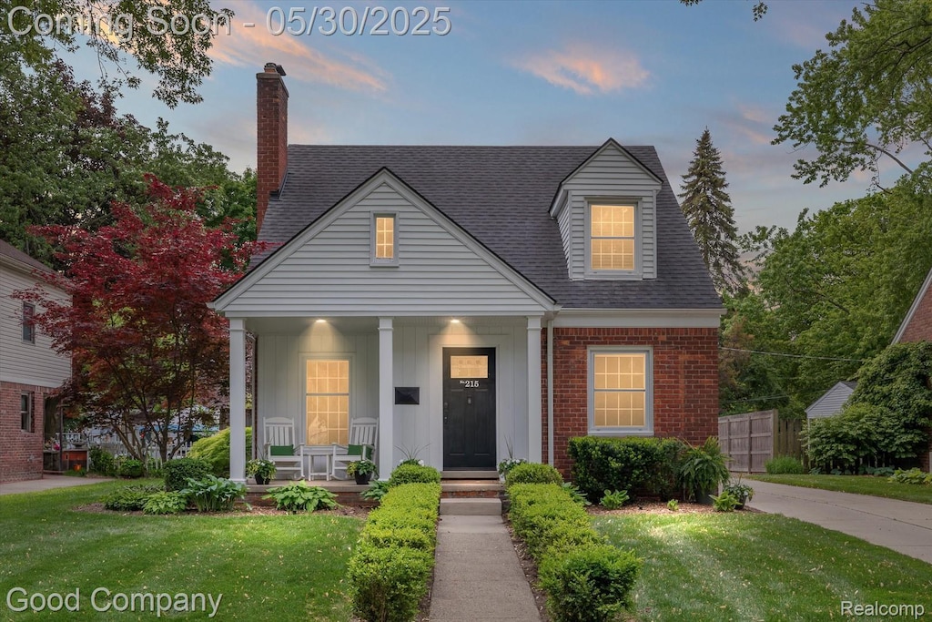 215 Aqua Ct, Royal Oak, MI 48073 - view of front of house featuring a porch, a lawn, roof with shingles, and brick siding