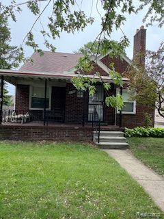 18598 Henry St, Melvindale, MI 48122 - view of front of house with covered porch, a front lawn, brick siding, and a chimney