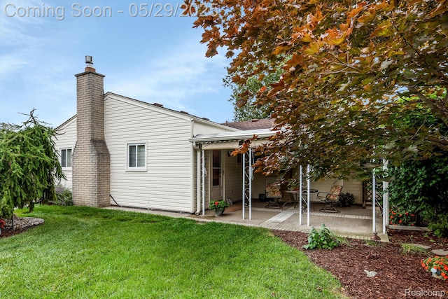 22540 Devonshire St, Woodhaven, MI 48183 - rear view of property with a patio area, a lawn, and a chimney