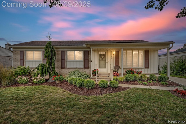 22540 Devonshire St, Woodhaven, MI 48183 - view of front of house featuring a yard, a porch, brick siding, and board and batten siding
