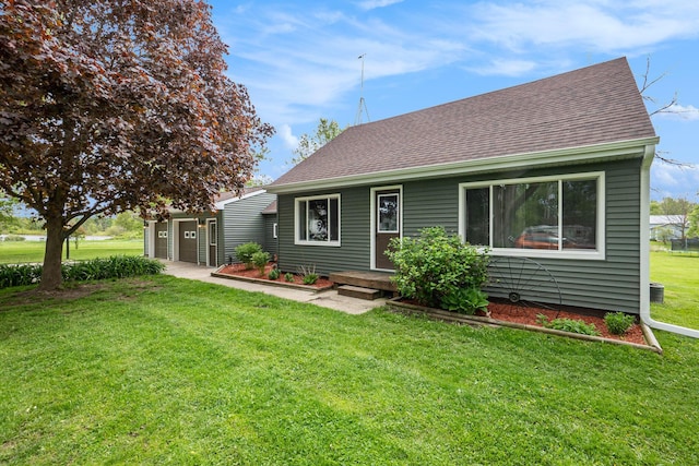 5778 Borland St, Sears, MI 49679 - back of property featuring a yard, a shingled roof, and a garage