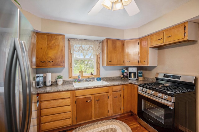 5778 Borland St, Sears, MI 49679 - kitchen with stainless steel appliances, a sink, dark wood-style flooring, ceiling fan, and brown cabinets