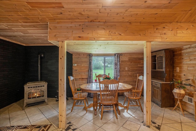 5778 Borland St, Sears, MI 49679 - dining area with wooden ceiling, a wood stove, light tile patterned floors, and wooden walls