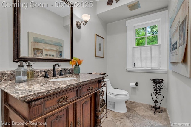 27160 Scenic, Franklin, MI 48025 - bathroom featuring baseboards, vanity, toilet, and stone tile floors