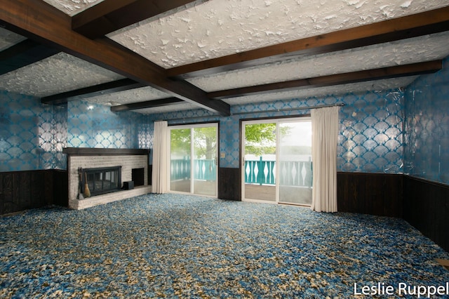 6221 Honeymoon Dr, Lakeview, MI 48850 - unfurnished living room with a wainscoted wall, wallpapered walls, carpet floors, a brick fireplace, and beam ceiling